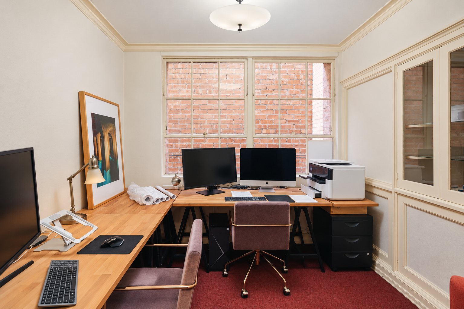 The private office at Rita House, with wood desks and a paned window
